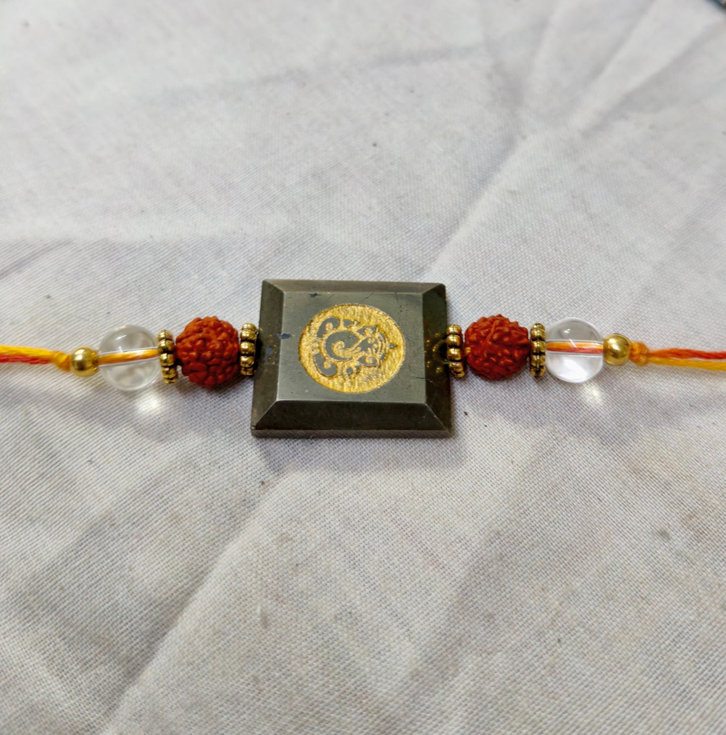Pyrite centerpiece with rudraksh and clear quartz rakhi-Ganesha-Maitri Export | Crystals Store