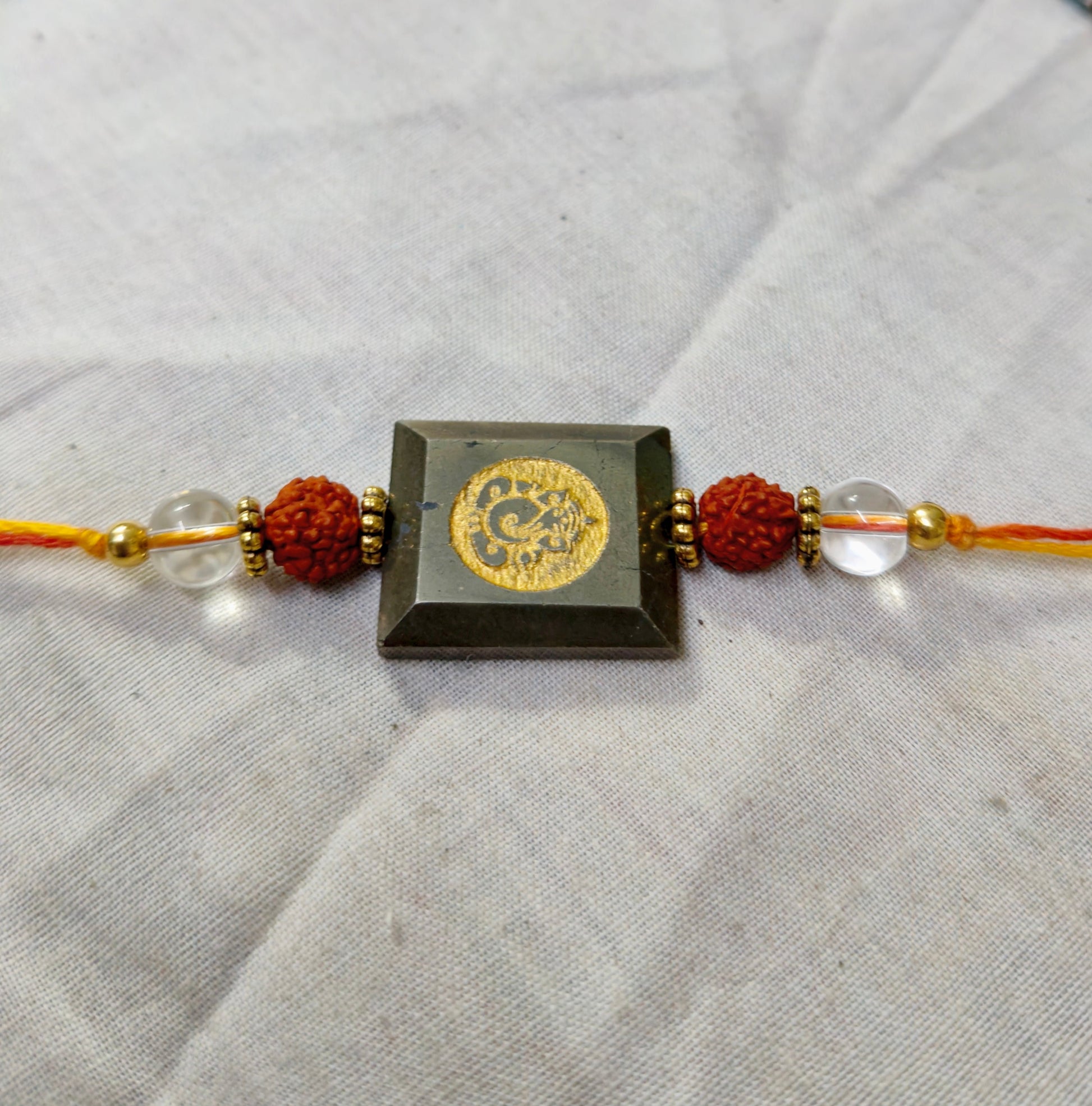 Pyrite centerpiece with rudraksh and clear quartz rakhi-Ganesha-Maitri Export | Crystals Store