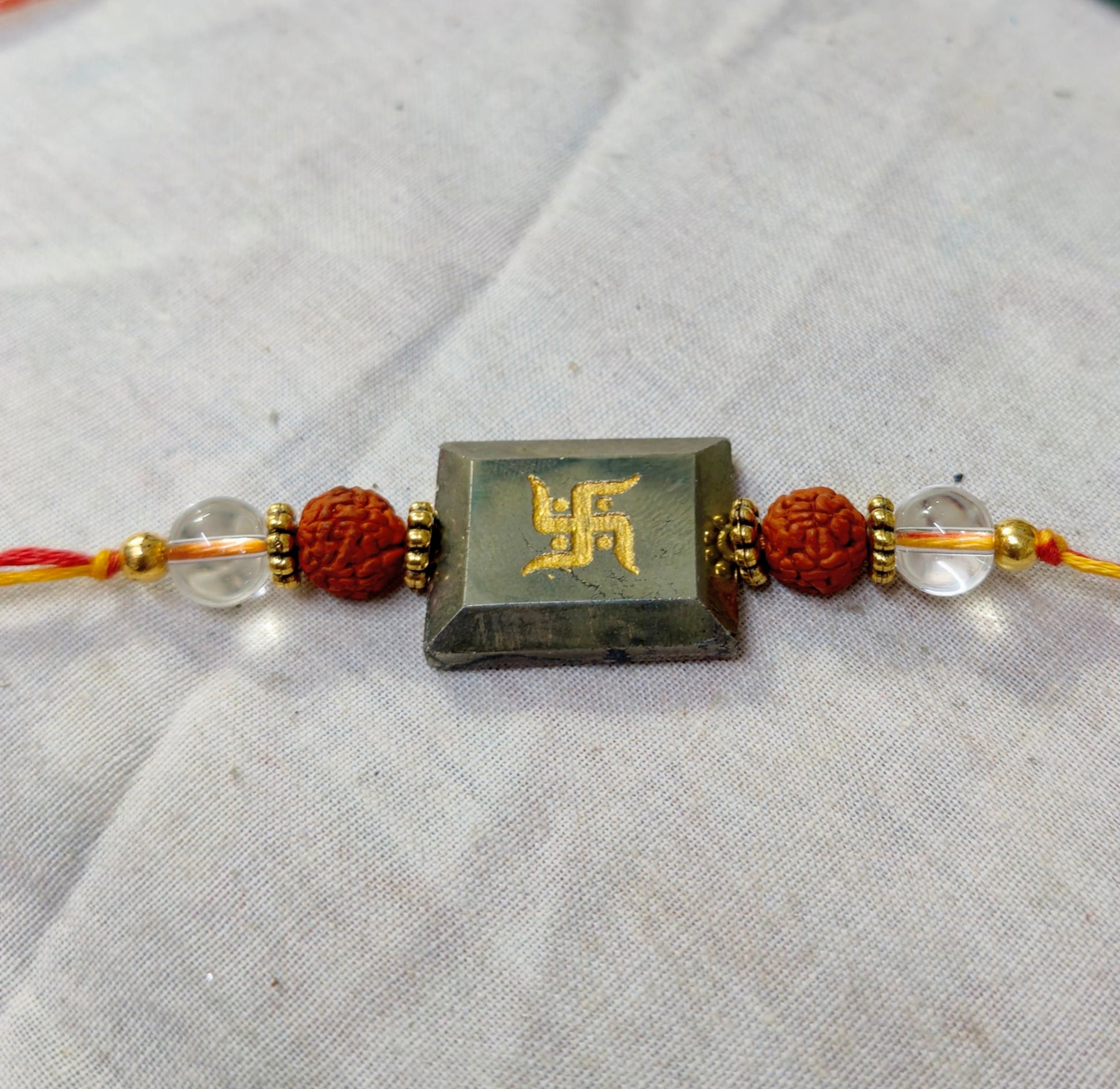 Pyrite centerpiece with rudraksh and clear quartz rakhi-Swastik-Maitri Export | Crystals Store